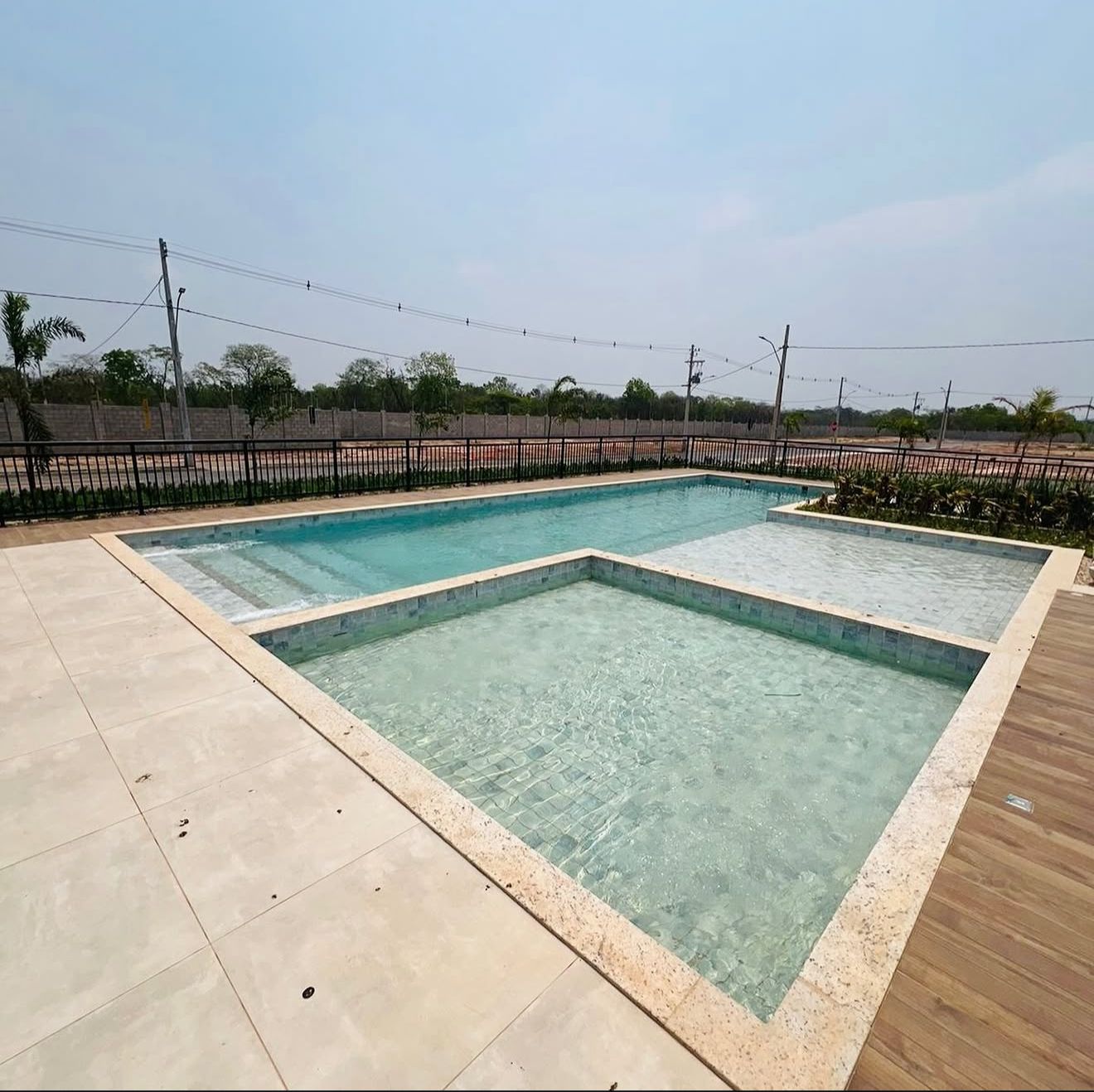 Piscina retangular com prainha e deck amadeirado